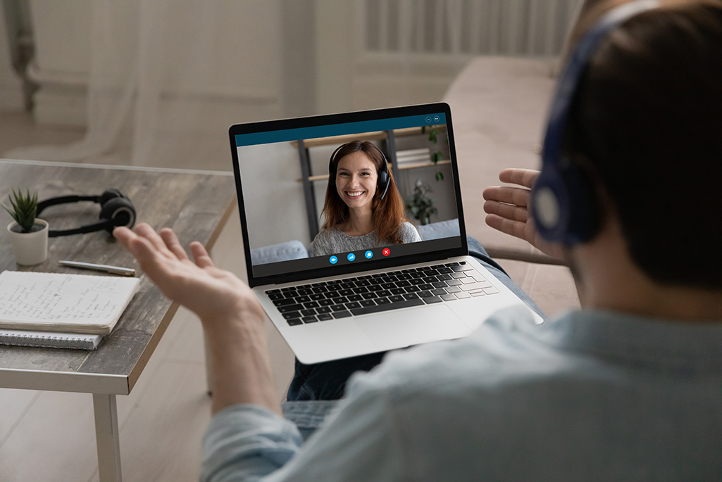 Bild visar en person vid en laptop som chattar med en annan person.